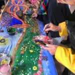 a close up of the member of the public painting a picture of a dragon on a long piece of paper