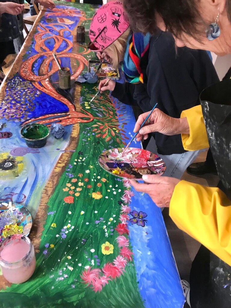 a close up of the member of the public painting a picture of a dragon on a long piece of paper