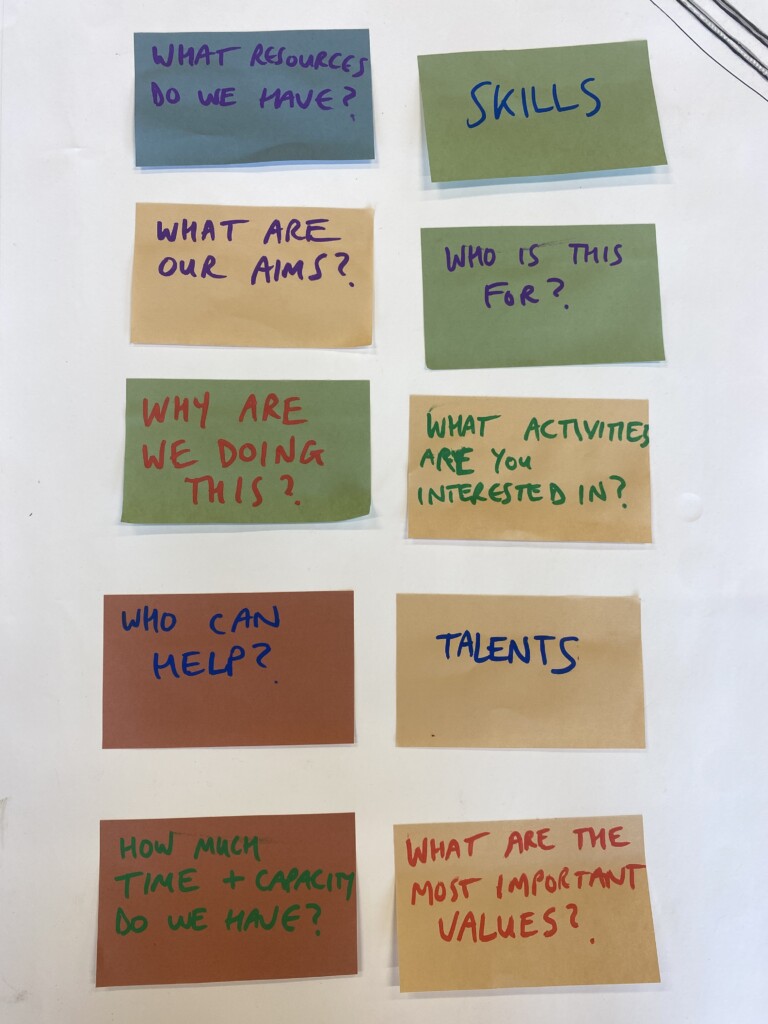 10 post it notes arranged in a grid, they say things like 'skills' 'who is it for? 'what are our aims?'