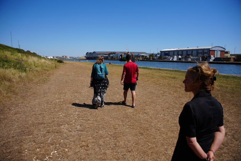 3 people walking along the side of Shoreham Port
