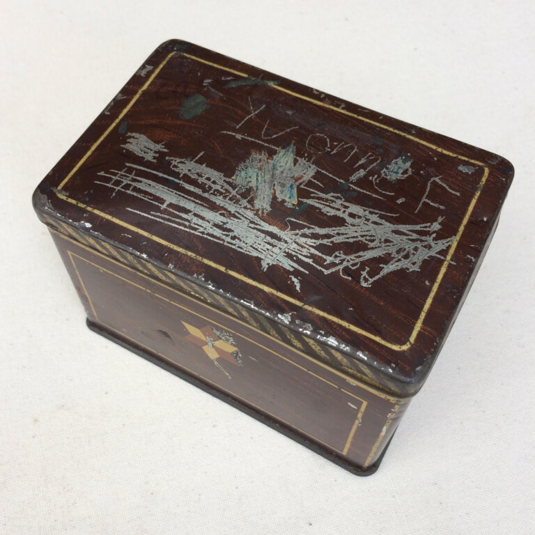 a maroon coloured small metal box. The lid has the paint scratched off