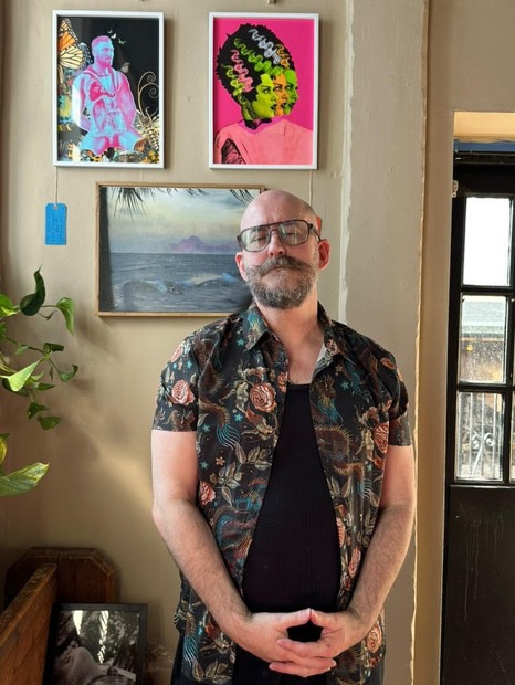 David G Taylor standing in front of his art works