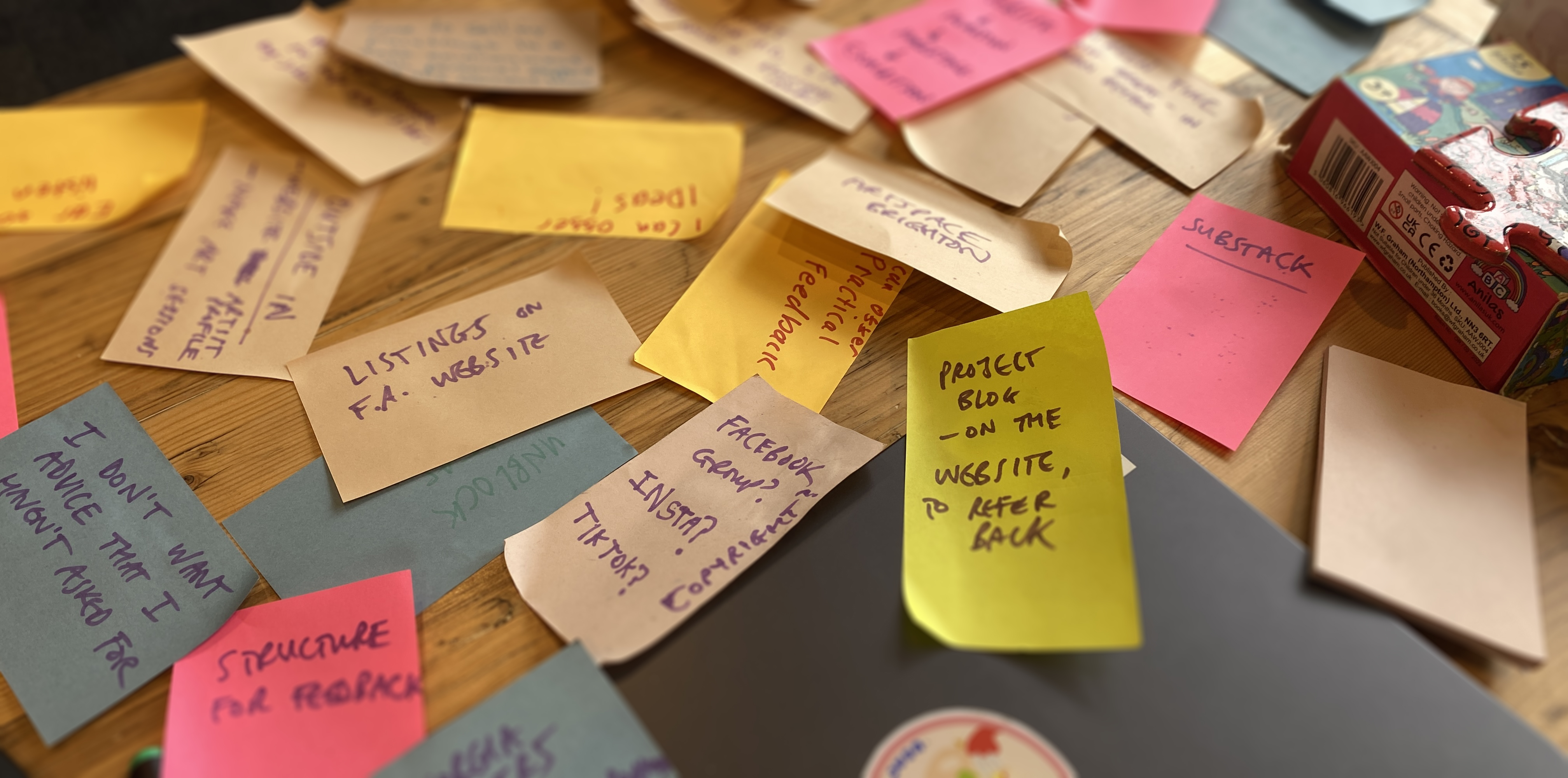 lots of colourful post-it notes on a table, with ideas about artist development