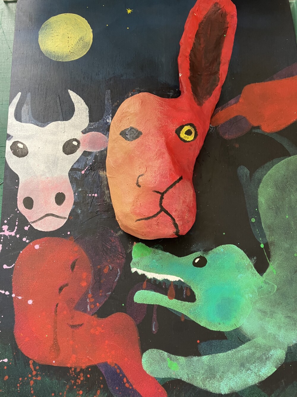 A painting of a green dog, a red hare and a cow, set against the moonlit night. The dog is baring it's teeth and attacking the red hare