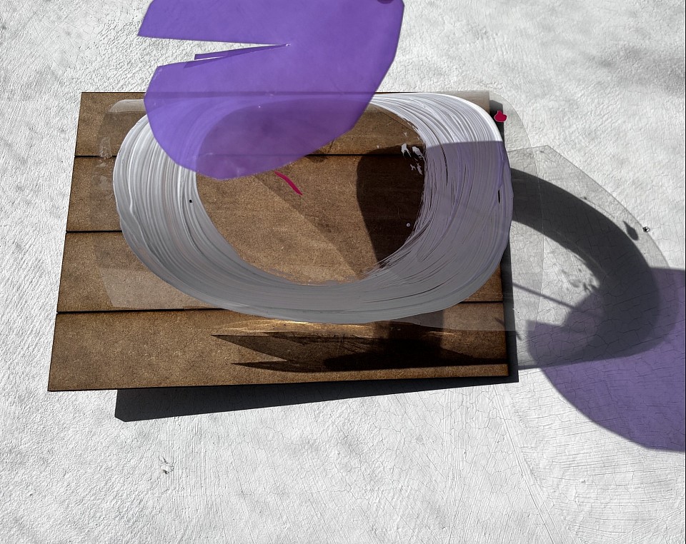 a sculpture using transparent coloured plastic, paint and wood casts colourful shadows