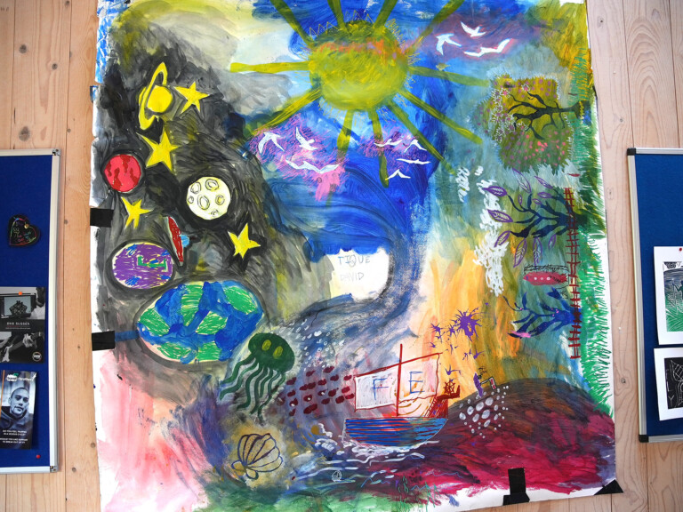 a large, colourful painting on paper. It depicts the sea, the sky, space and the planets and the earth
