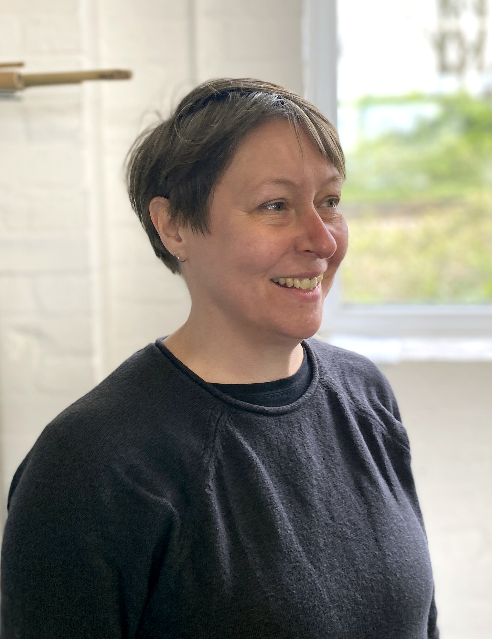 a photograph of Yvonne, a woman with short hair and a dark sweatshirt.